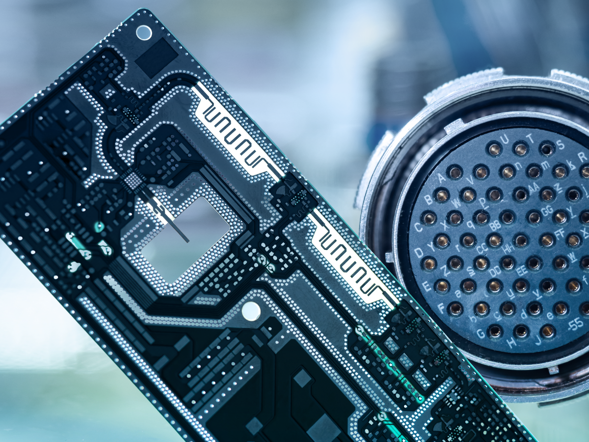 Close-up of a computer circuit board next to a circular electronic connector with multiple pins, set in a blue-toned, high-tech environment—ideal for precise High-Voltage Test applications. by Standex Detect