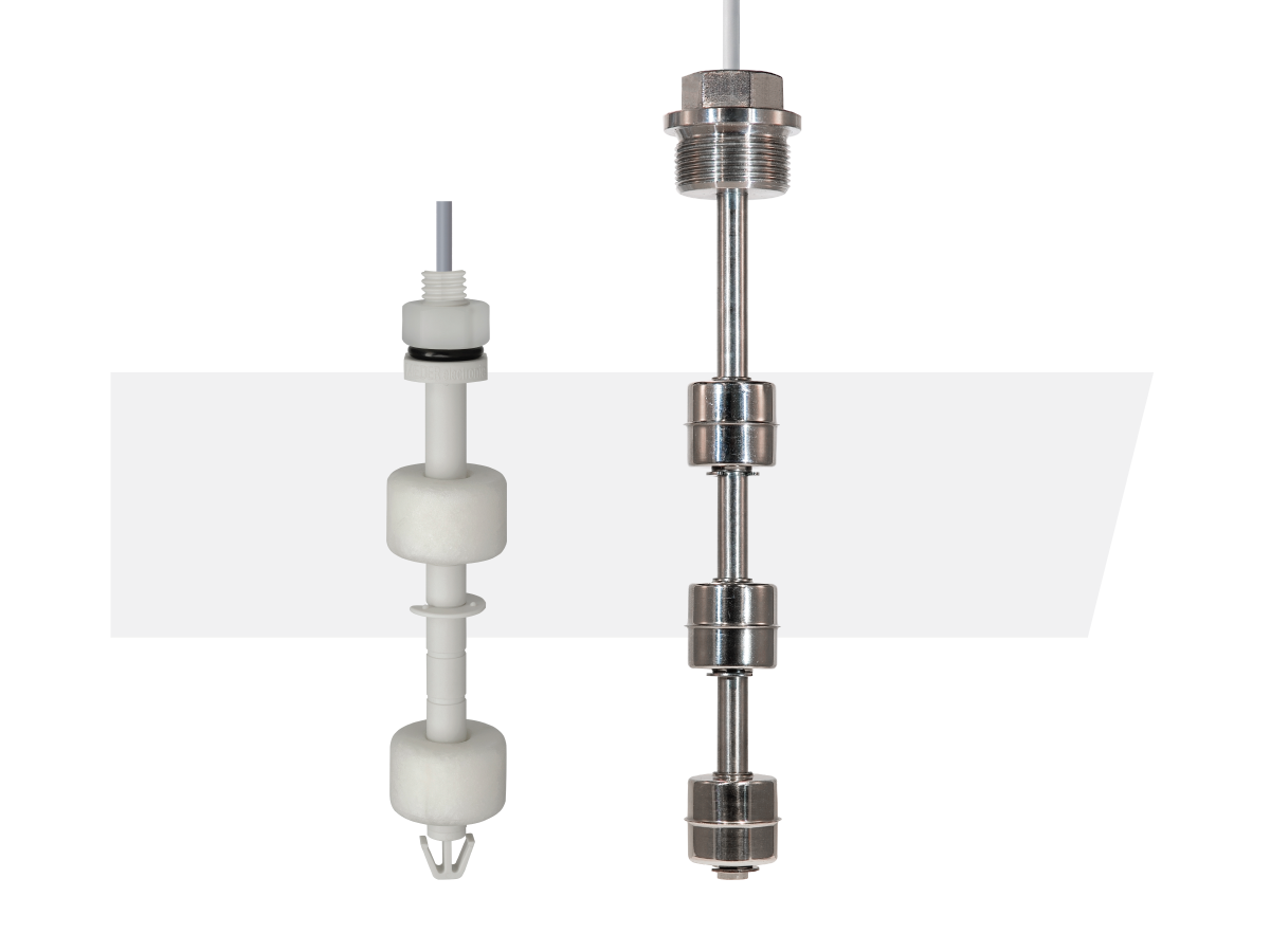 Two vertical liquid level sensors are shown side by side against a white background; one is an energy efficient sensor made of white plastic with float switches, and the other is metal with cylindrical float switches and threaded fittings. by Standex Detect