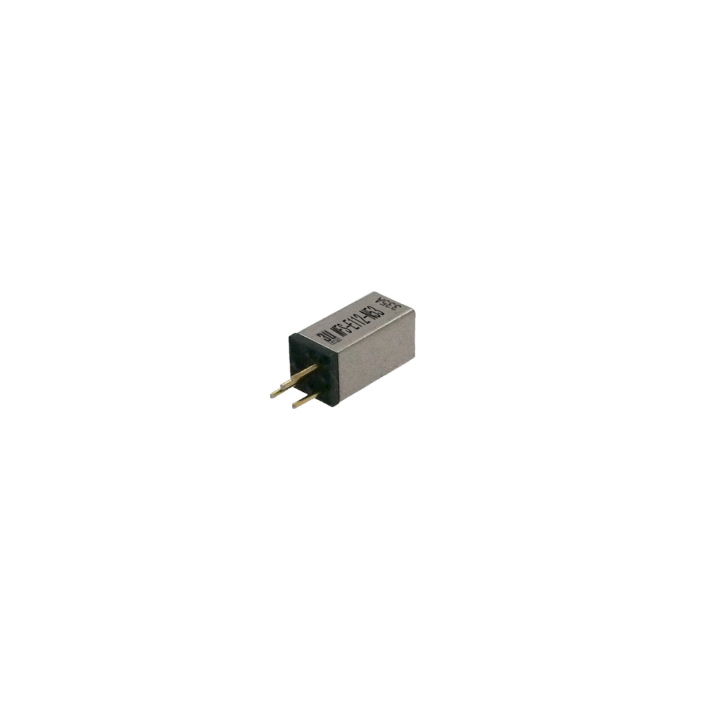 A small rectangular electronic component with two gold pins extending from one end, and black and silver casing with alphanumeric markings on the top surface, shown against a white background. by Standex Detect