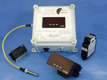 Analog sensor controller kit with display and various sensor components—including sensors to measure speed, a yellow cable, metal probe, electronic modules, and control box—all arranged on a blue surface. by Standex Detect